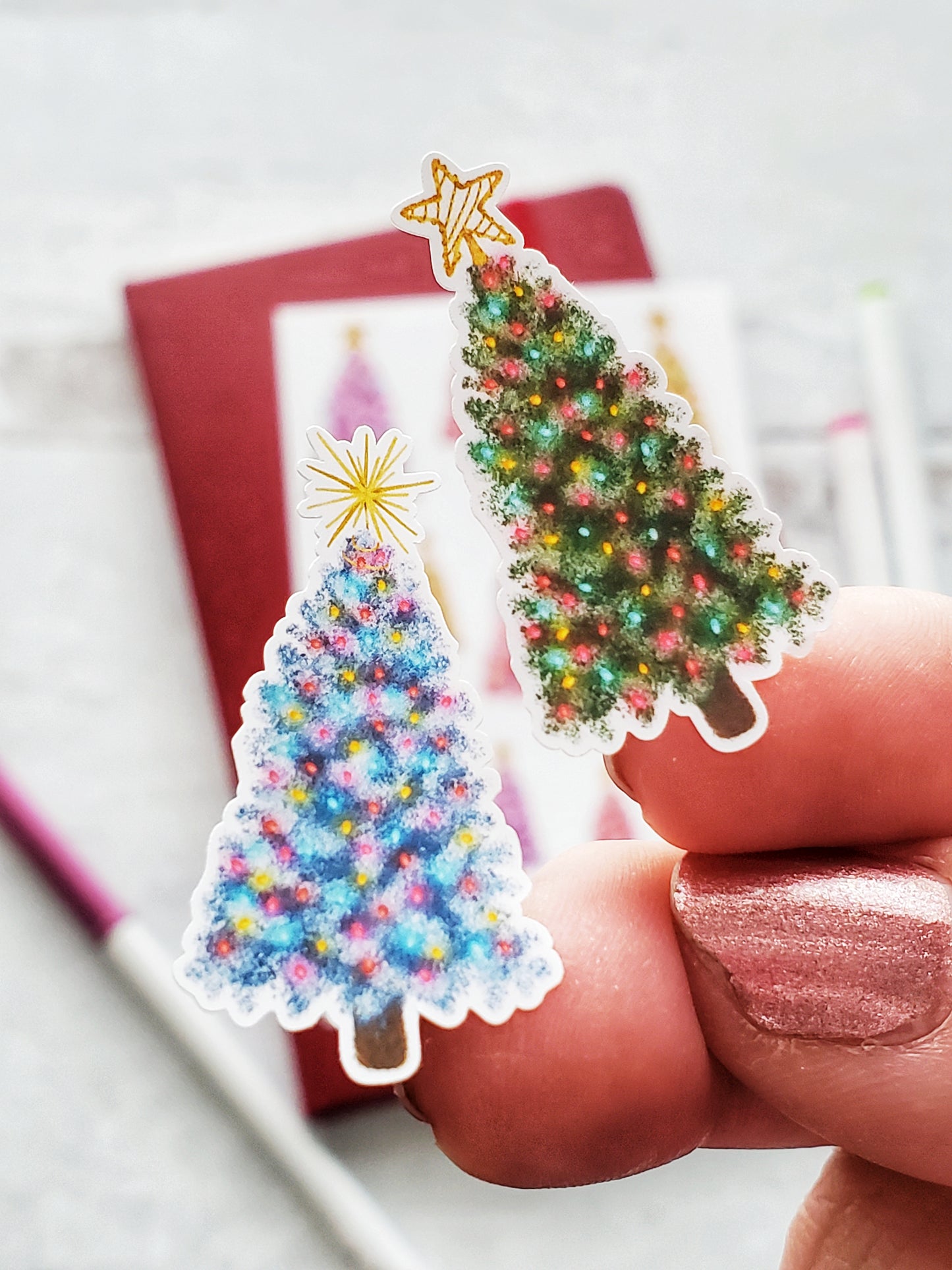 Close up of 2 Christmas tree stickers. One is green the other is blue.