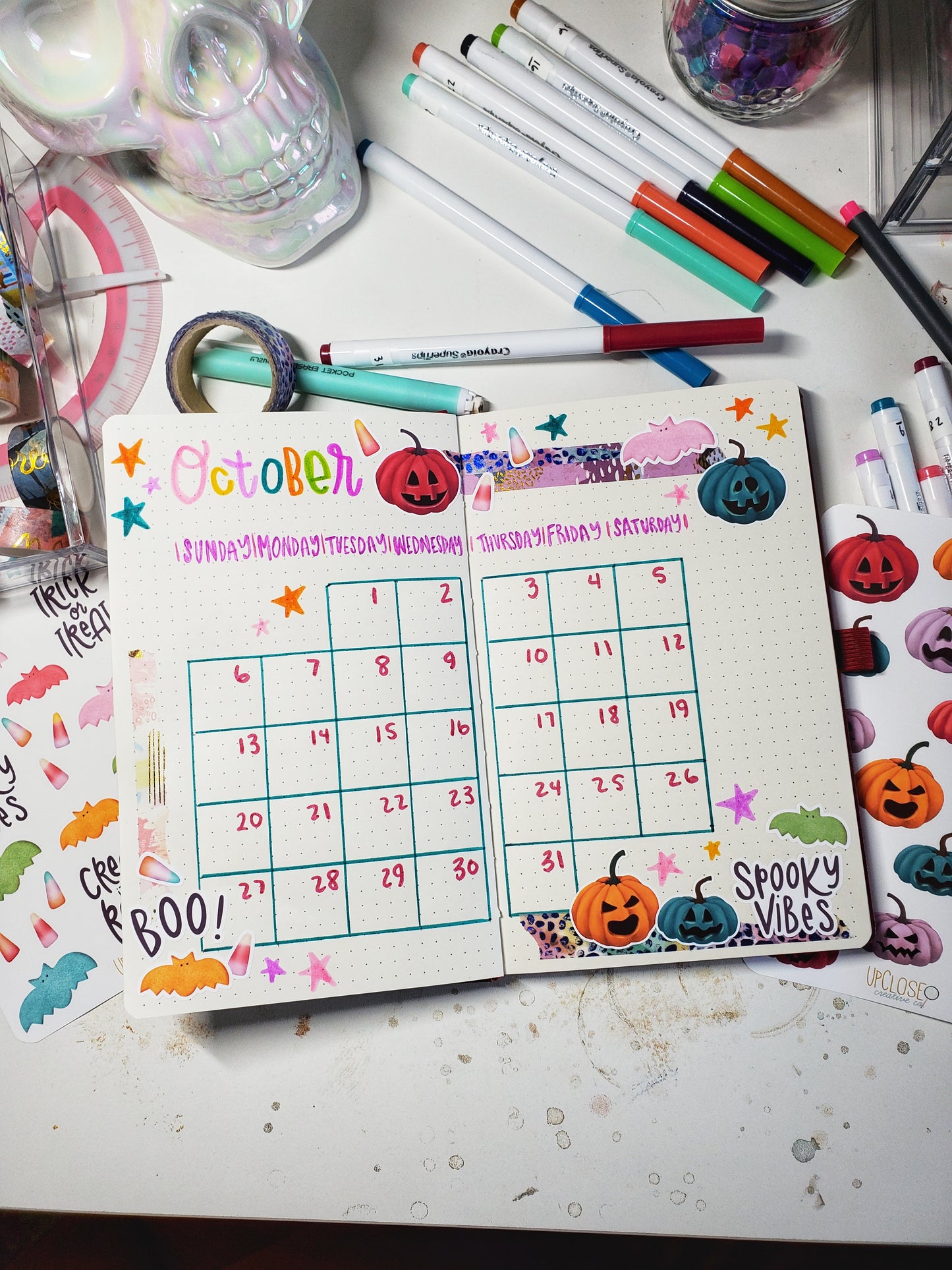 An example of a bullet journal calendar spread decorated with the jack-o-lantern stickers.