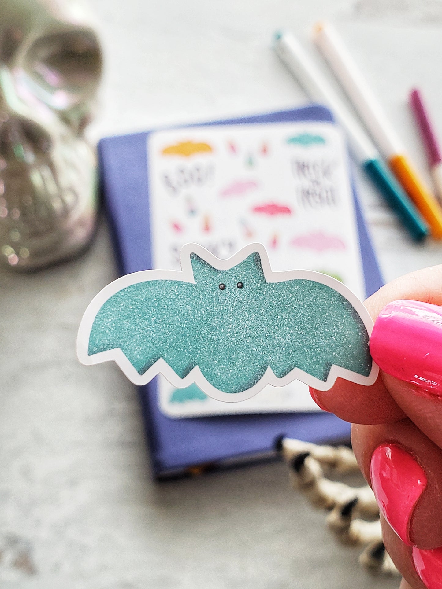 A close up of a sticker of a blue gummy bat.
