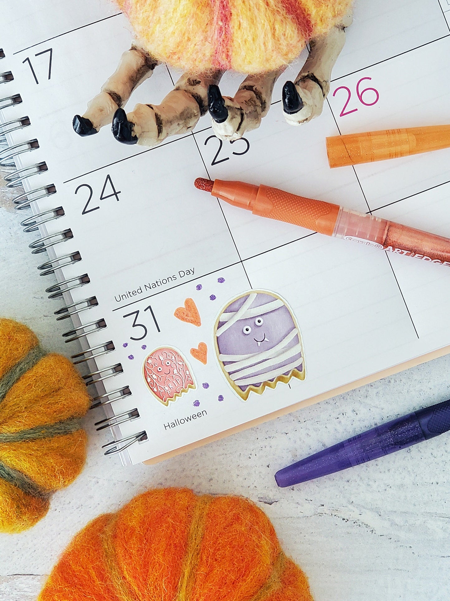Two ghost cookie stickers placed on a planner page