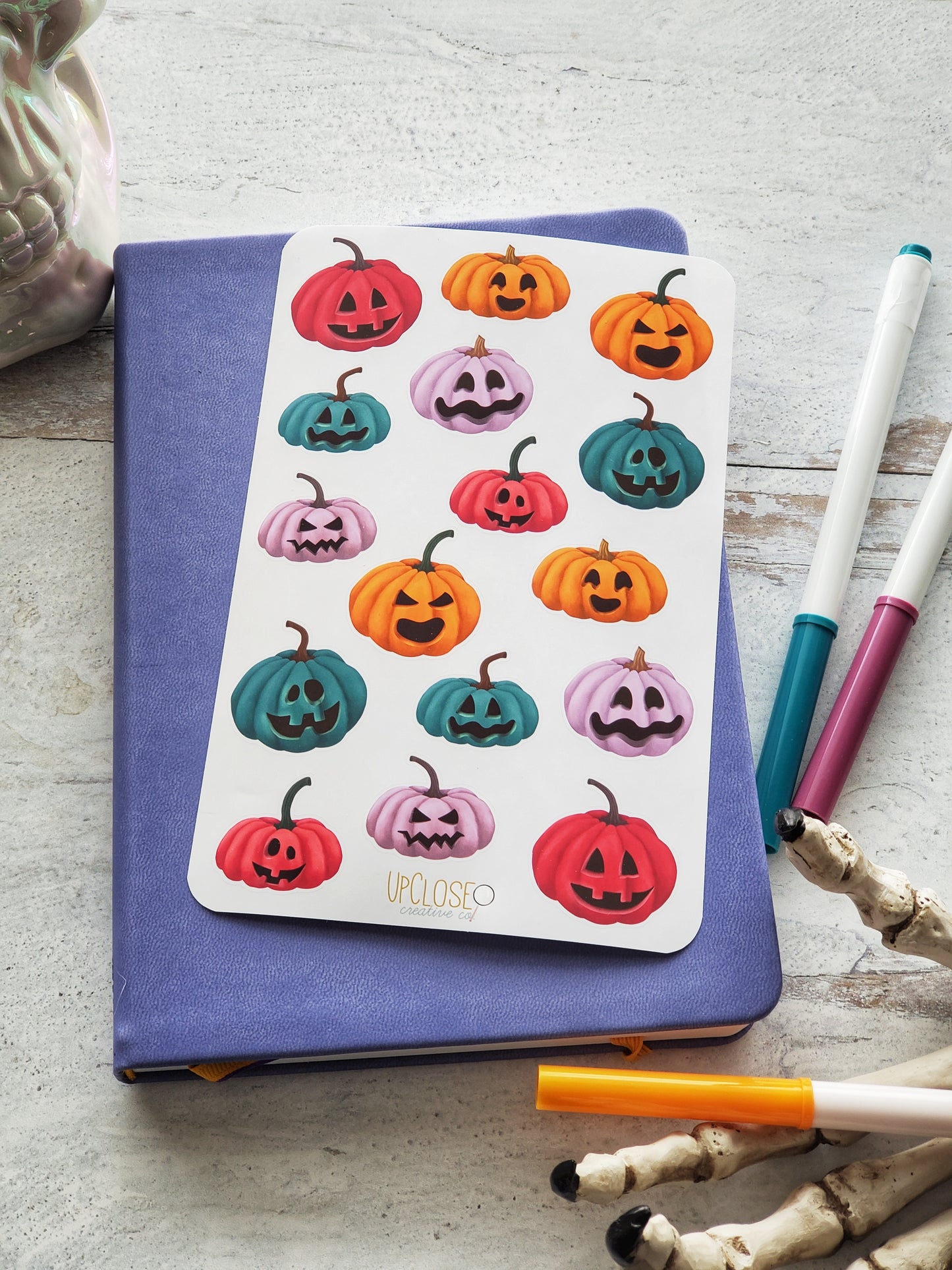 Sticker sheet of jack-o-lanterns in a variety of colors. Pink, teal, purple and orange.