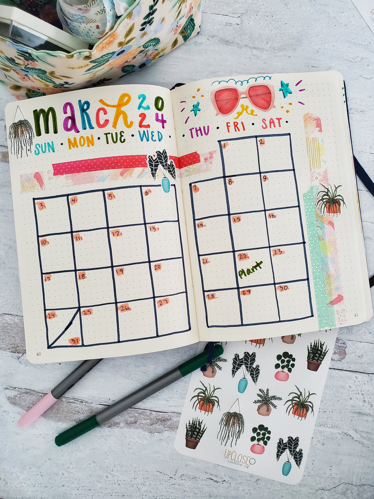 A very colorful bullet journal calendar spread decorated with the plant stickers.