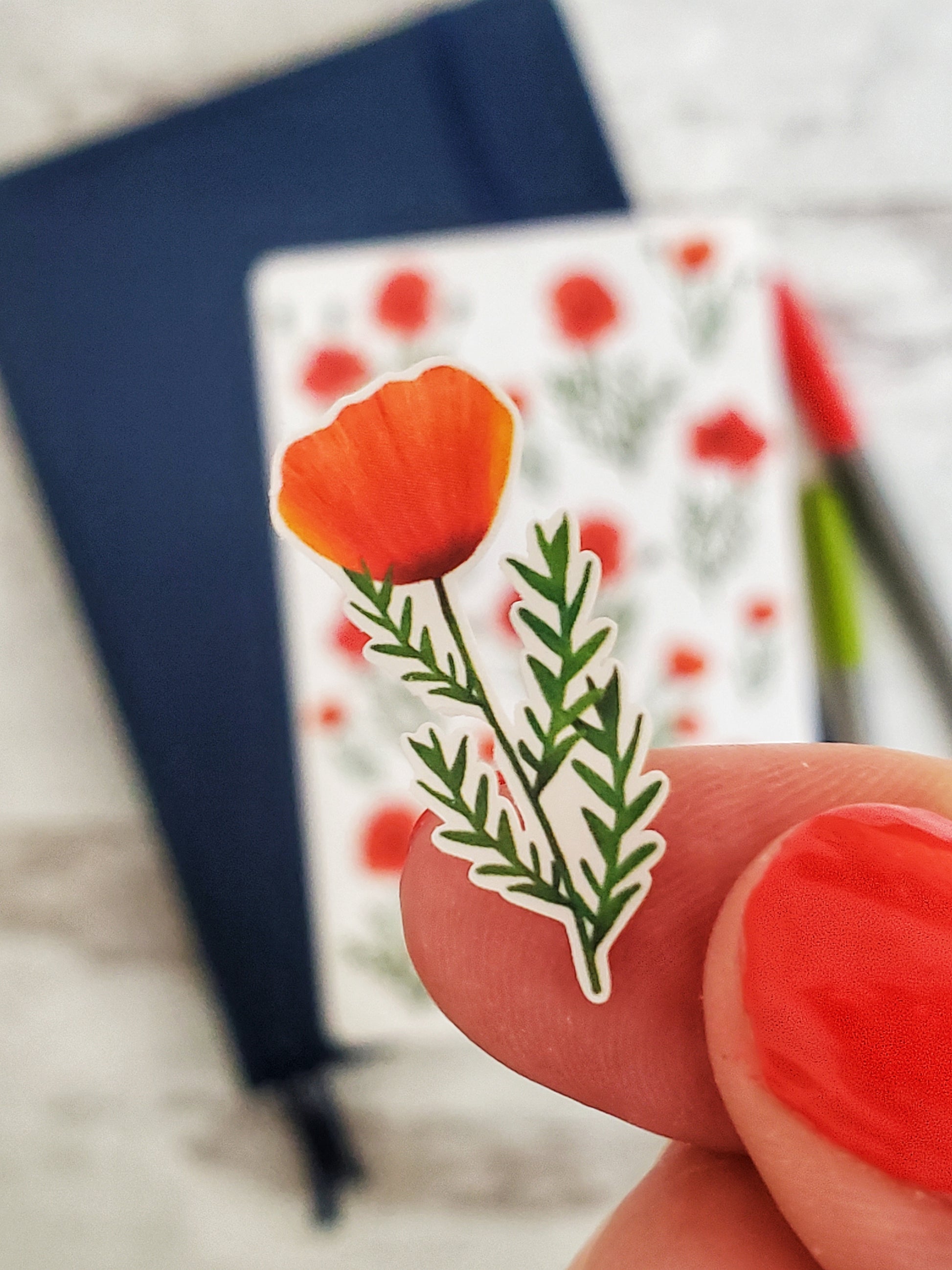 A close up of a small red poppy sticker
