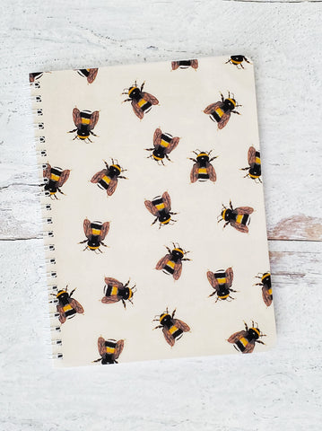 wire bound notebook with illustrated bumble bee pattern on beige background 