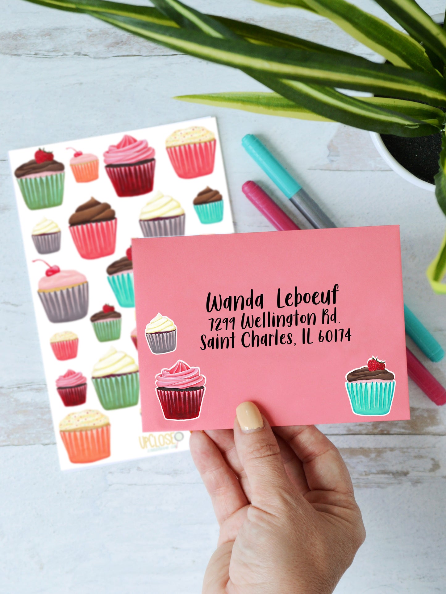 A mailing envelope decorated with a variety of cupcake stickers.