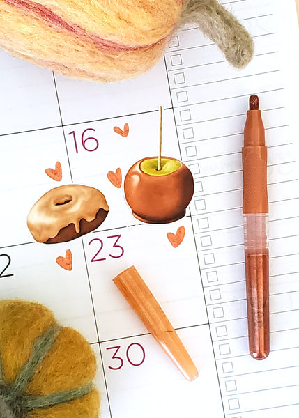maple donut and caramel apple sticker on a planner page with heart doodles