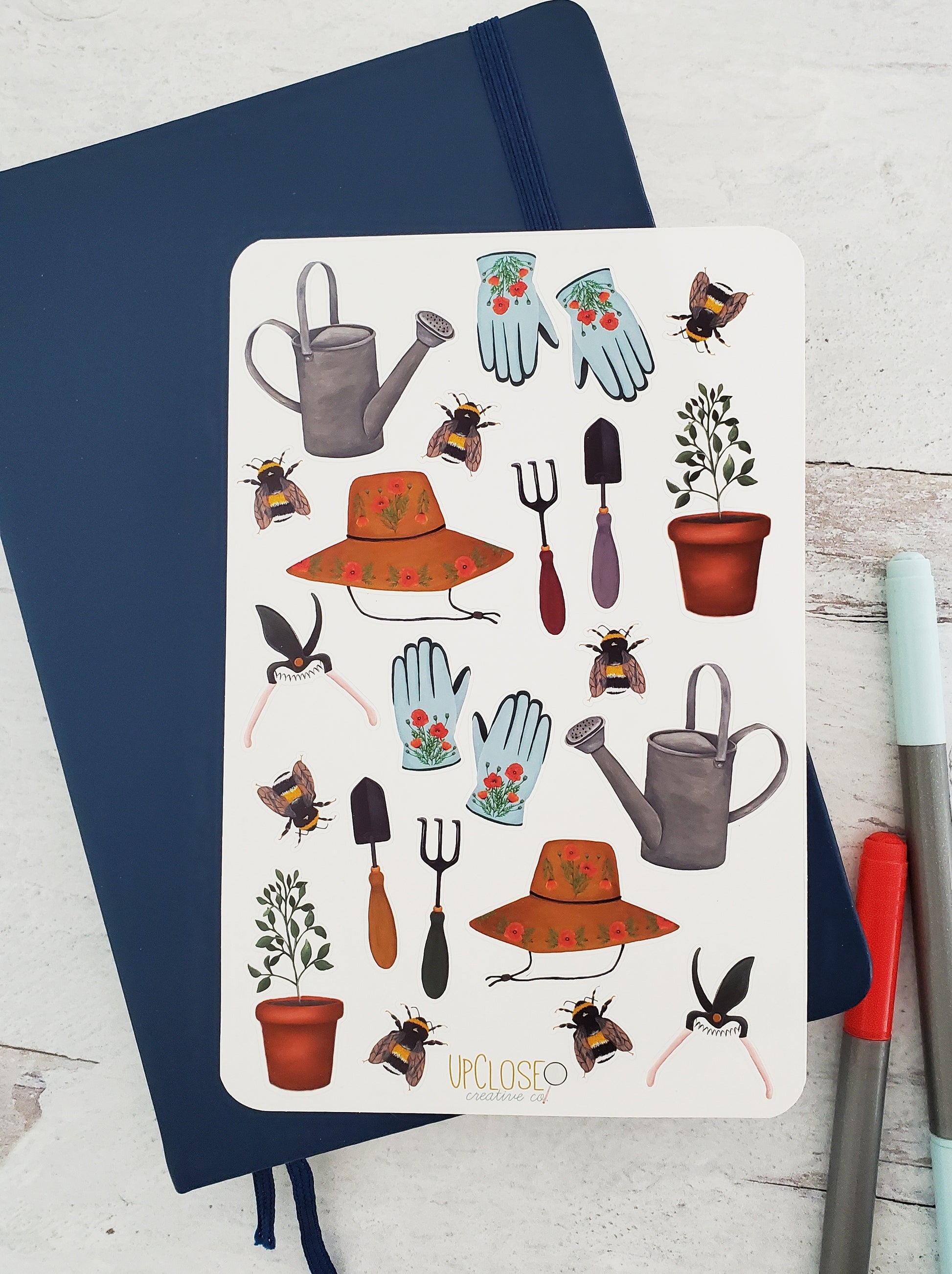 Sticker sheet with assorted gardening themed items. Includes watering can, gloves, hat, garden tools, bees and a plant.