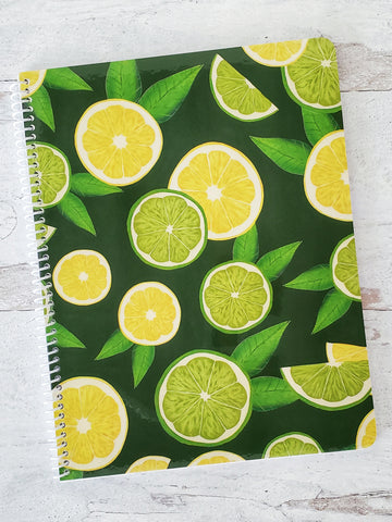 dark green spiral notebook with illustrated lemon and lime slices pattern on the cover