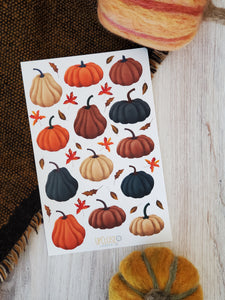 sticker sheet with illustrated pumpkins of various shapes and sizes in deep blue, mauve, orange and cream with small fall leaves