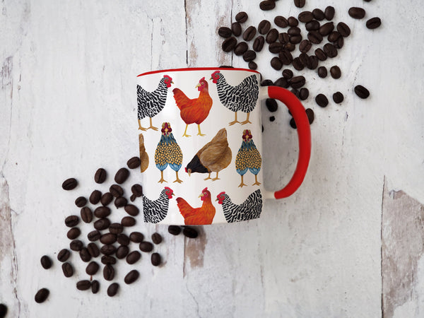 red handled chicken mug laying on weathered wood surrounded by coffee beanss