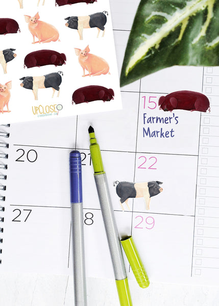 red pig and black and white pig stickers shown on a planner page